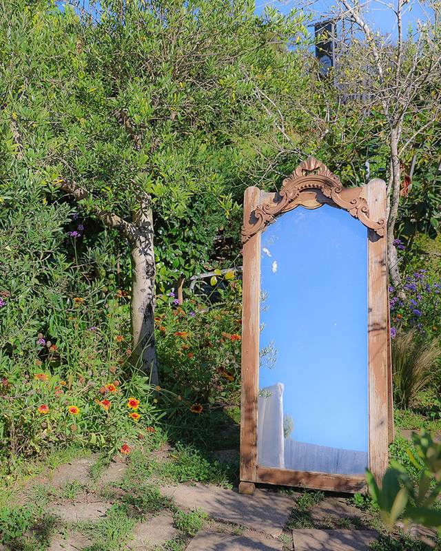 Ein alter Spiegel im blühenden Garten